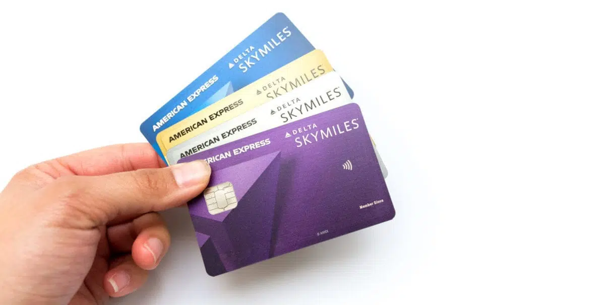 person holding four delta airlines credit cards