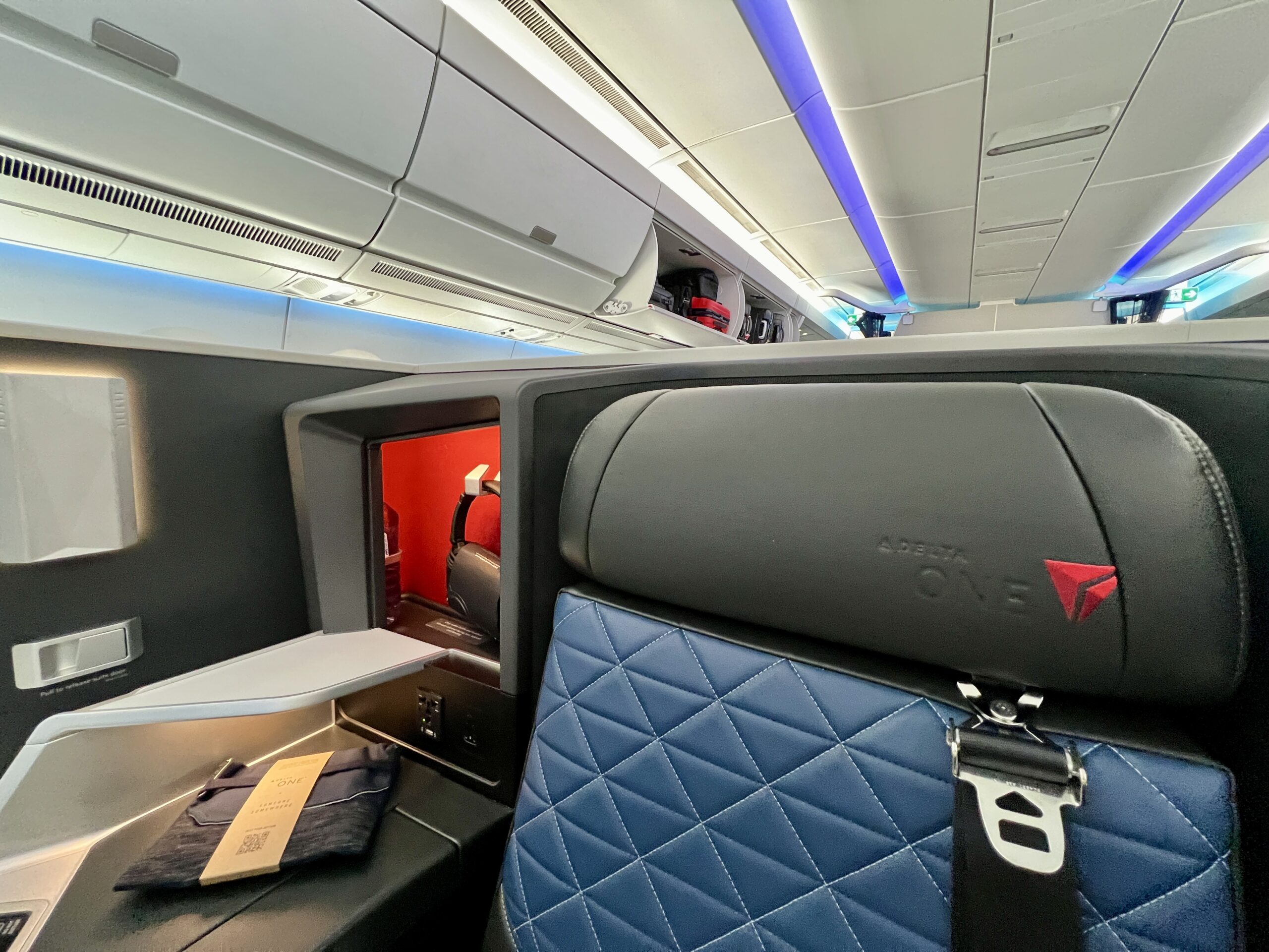 an airline seat inside suite walls with a seatbelt