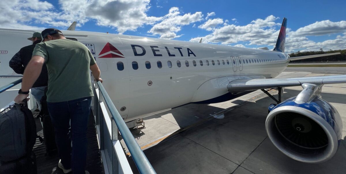 passengers boarding delta plane on tarmac