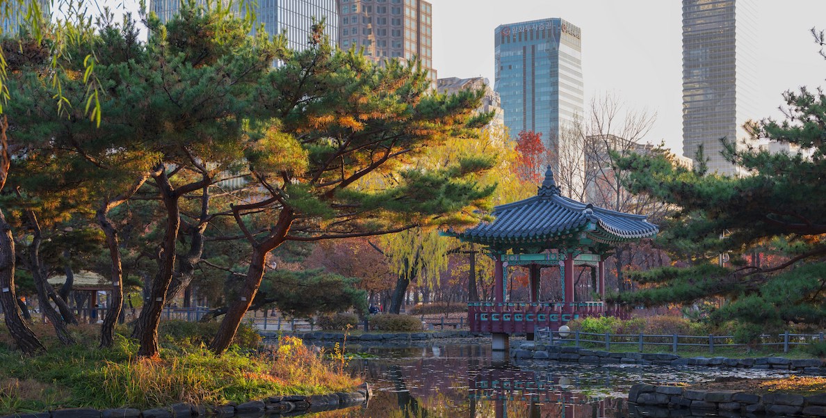 a pond with a structure in a park in seoul, south korea