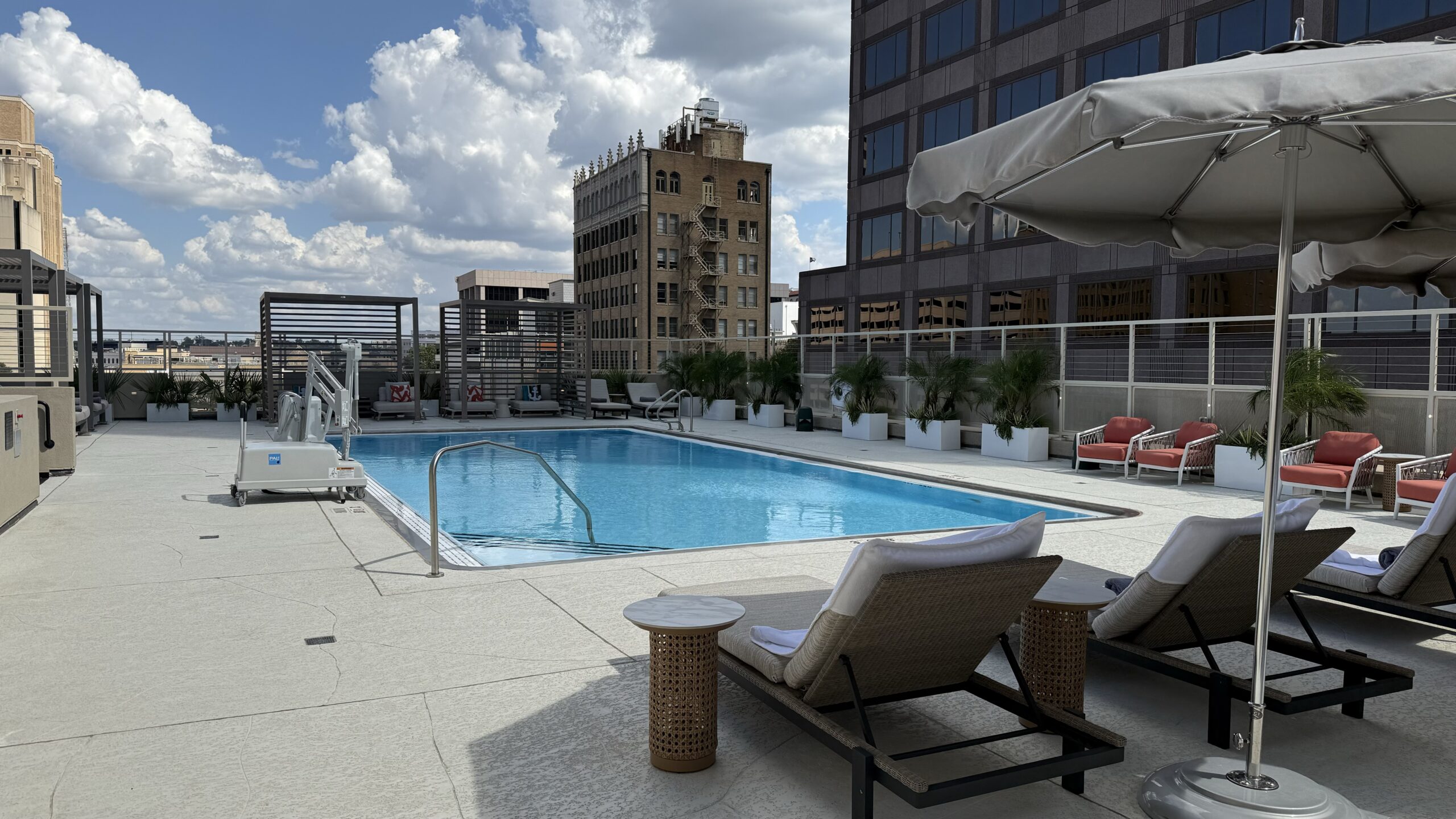 Rooftop pool, loungers, and an umbrella for shade. 