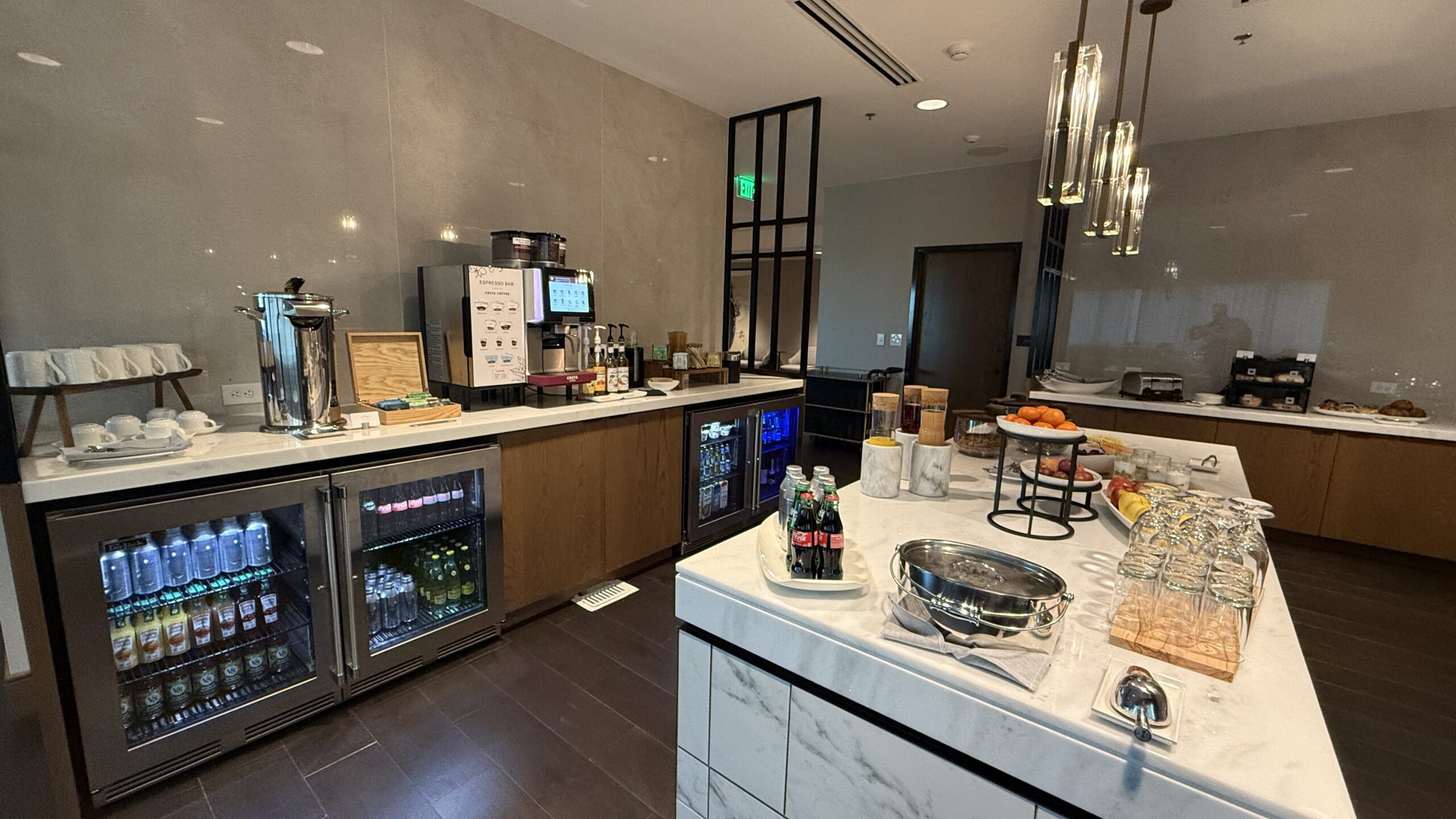 buffet with drinks, fruit, and coffee maker.