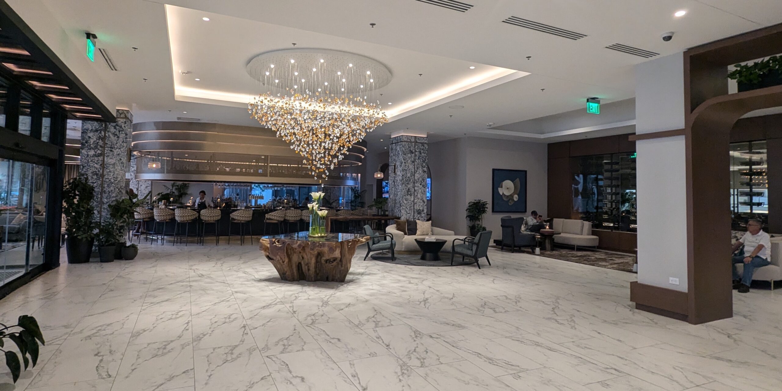 Hotel lobby with bar, chandelier, and seating.