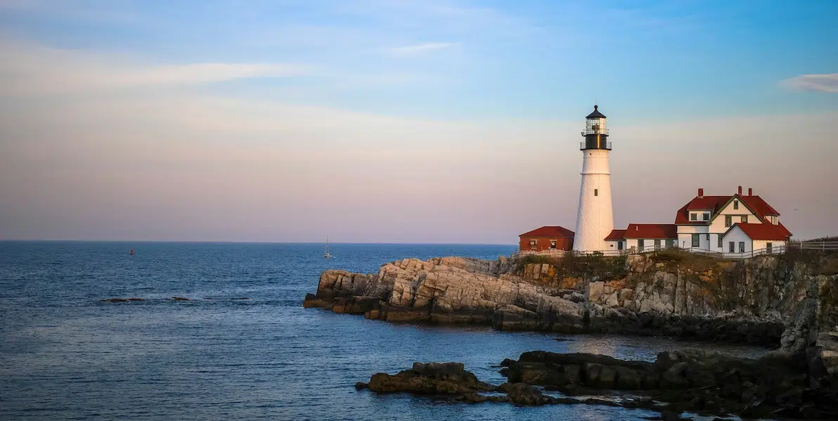 lighthouse on a rocky shore at sunrise