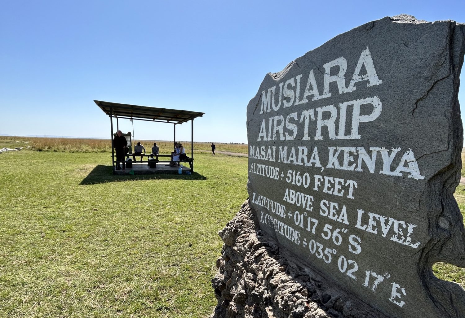 A sign on top of a grass covered field