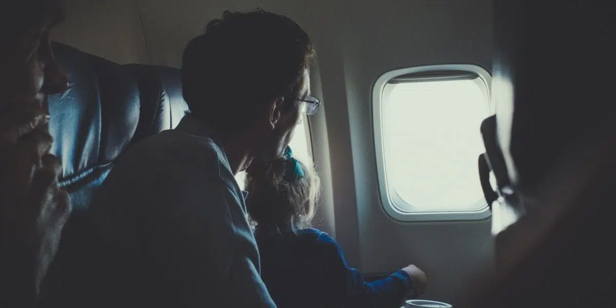 A man sitting in front of an airplane window