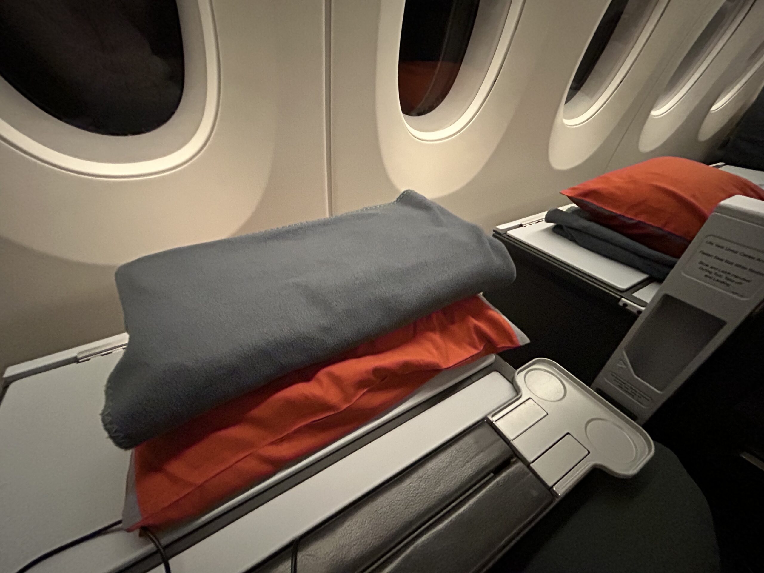 pillow and a blanket on an airplane tray table