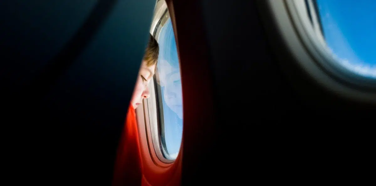 a kid looking out an airplane window