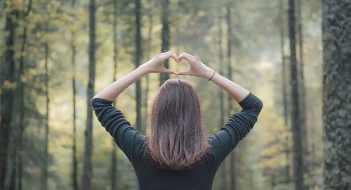 A woman standing in front of a forest