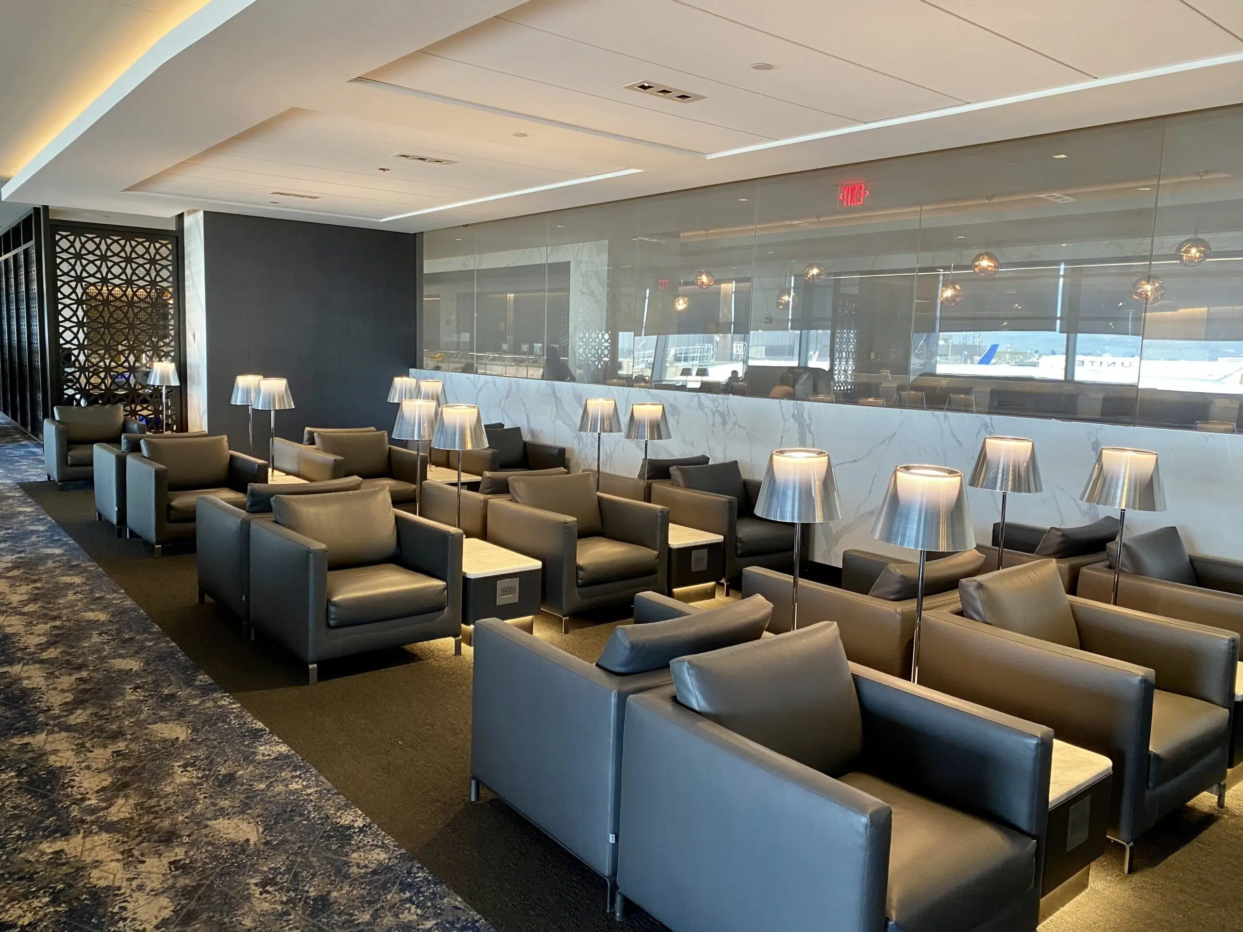 many armchairs with lamps inside the united polaris lounge in newark